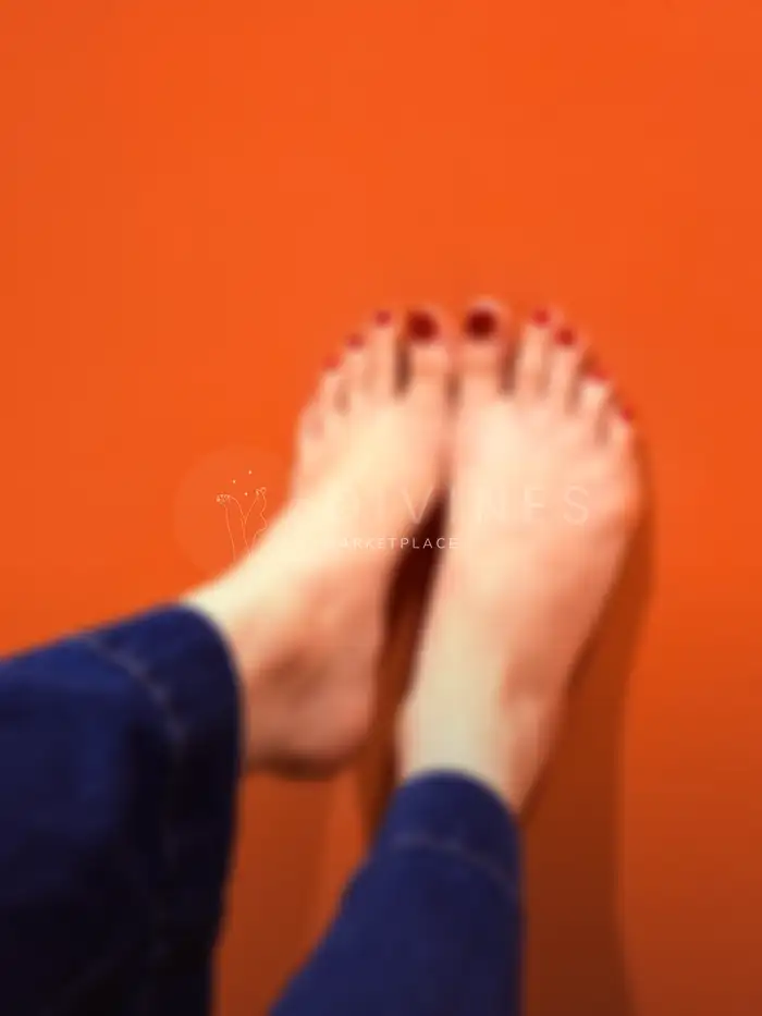 Pieds cambrés vernis rouge sous lumière tamisée