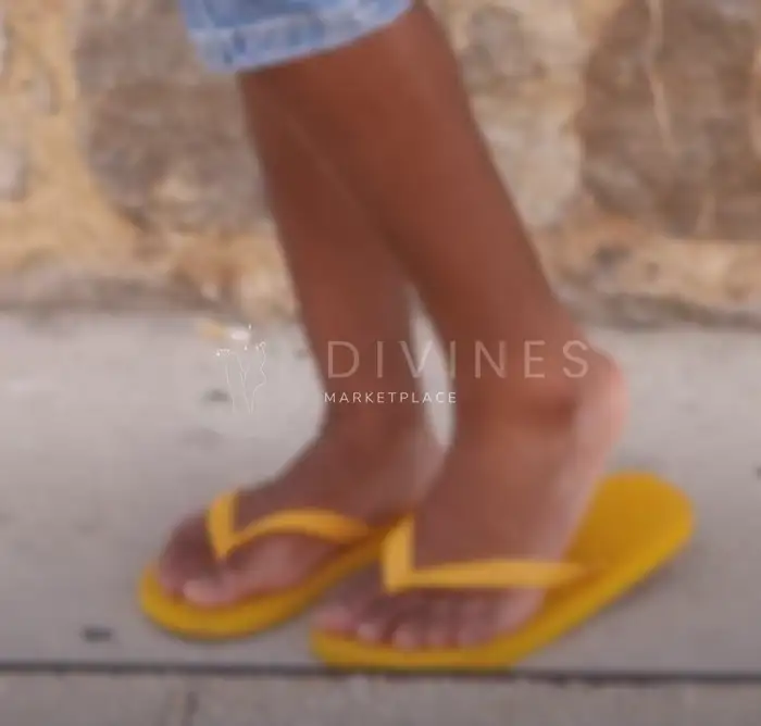 Pieds cambrés en tongs Havaianas sur sable chaud